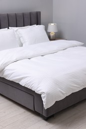 Photo of Bed with clean linens and pillows indoors