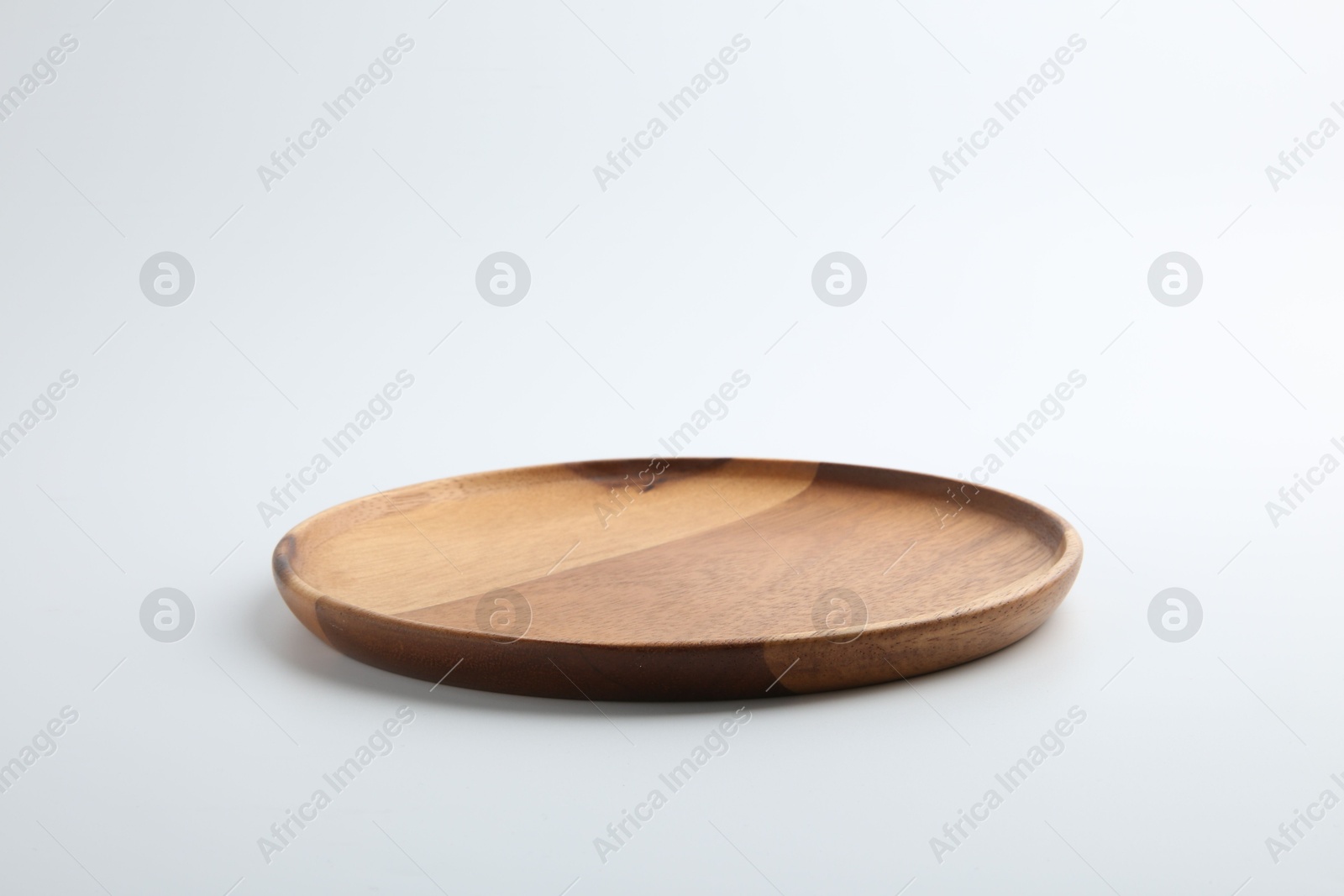 Photo of One wooden plate on white background. Tableware