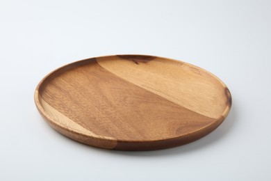 Photo of One wooden plate on white background. Tableware