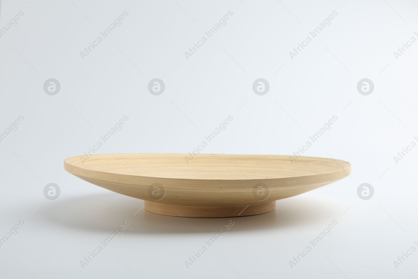 Photo of One wooden plate on white background. Tableware