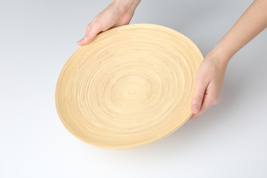 Woman holding wooden plate on white background, closeup