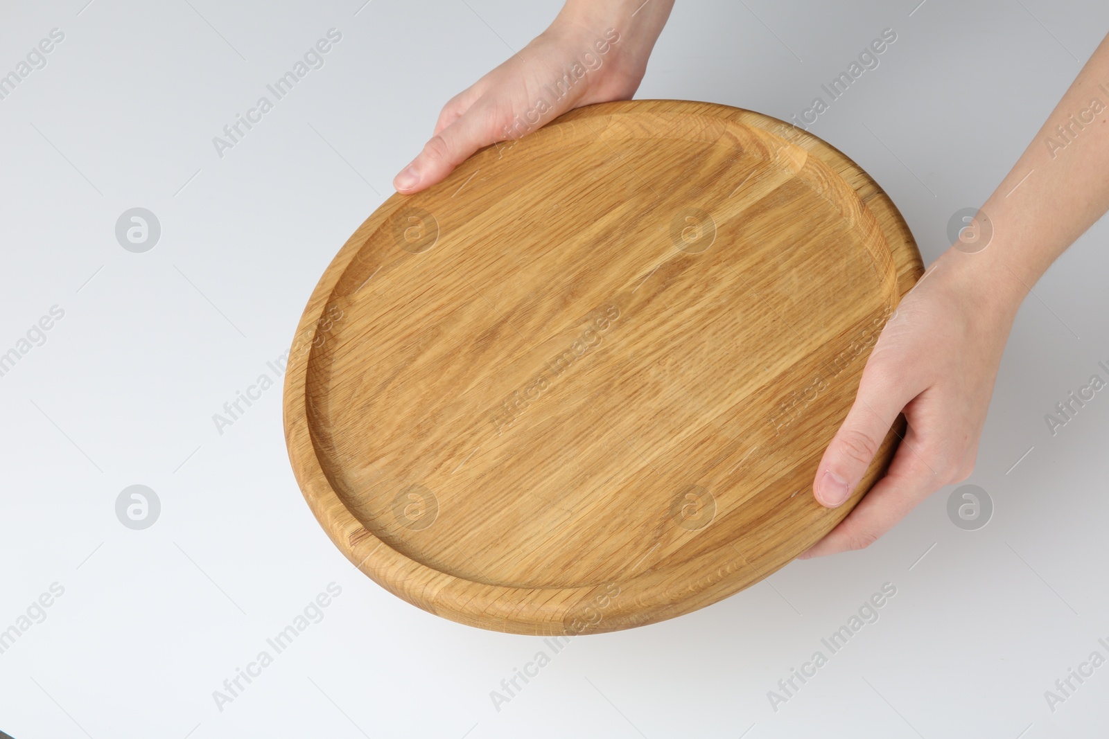 Photo of Woman holding wooden plate on white background, closeup