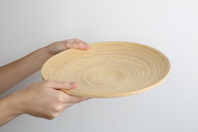 Woman holding wooden plate on white background, closeup