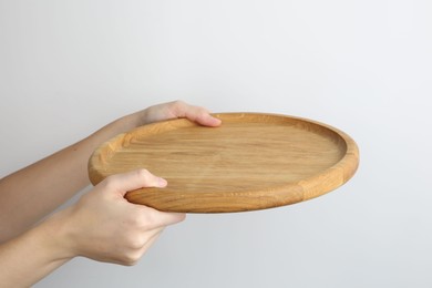 Photo of Woman holding wooden plate on white background, closeup