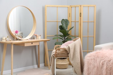 Mirror, dressing table, houseplant, folding screen and chair indoors. Interior design