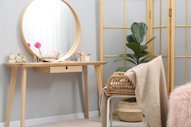 Mirror, dressing table, houseplant, folding screen and chair indoors. Interior design