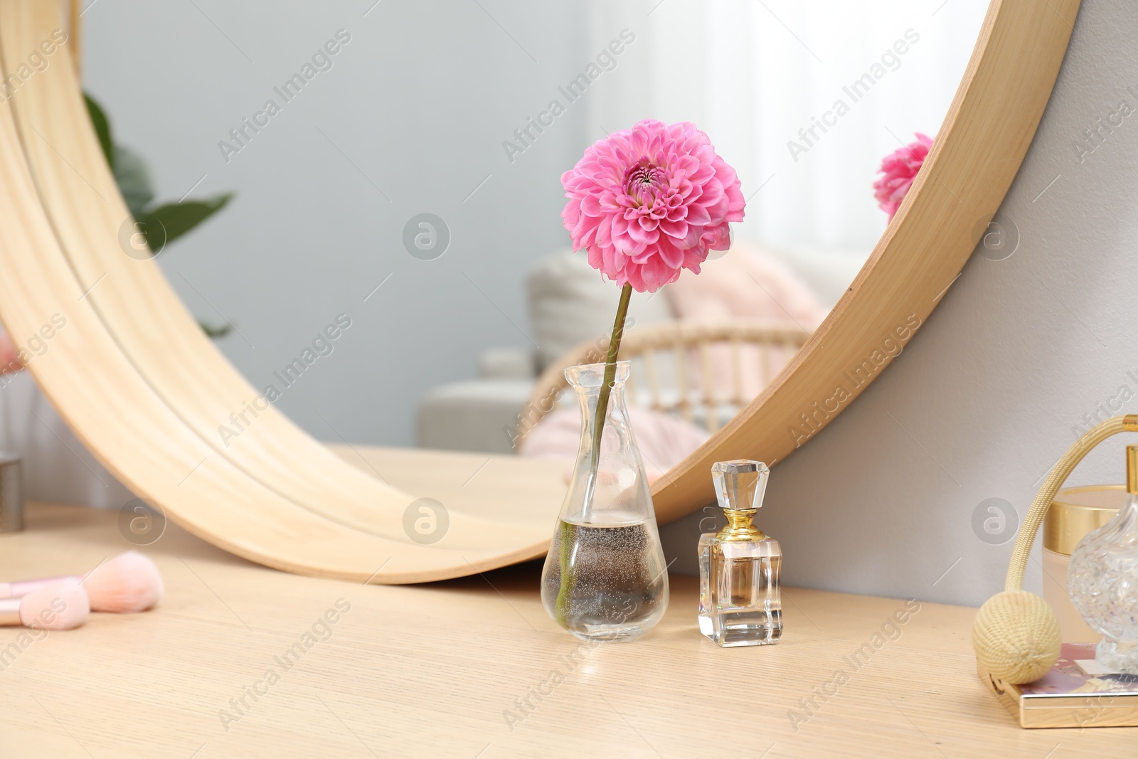 Photo of Dressing table with mirror, cosmetic products and flower indoors. Interior design