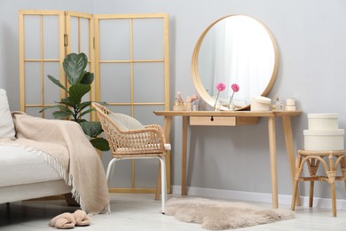 Mirror, dressing table, houseplant, folding screen and chair indoors. Interior design