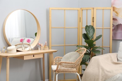 Mirror, dressing table, houseplant, folding screen and chair indoors. Interior design