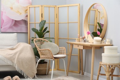 Mirror, dressing table, houseplant, folding screen and chair indoors. Interior design