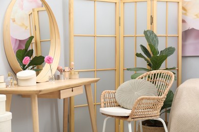 Photo of Mirror, dressing table, houseplant, folding screen and chair indoors. Interior design