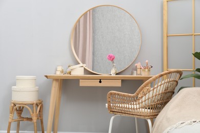 Photo of Mirror, dressing table and chair indoors. Interior design