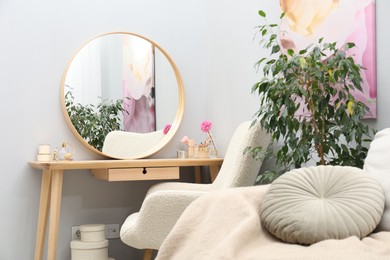 Photo of Mirror, dressing table, houseplant, sofa and armchair indoors. Interior design