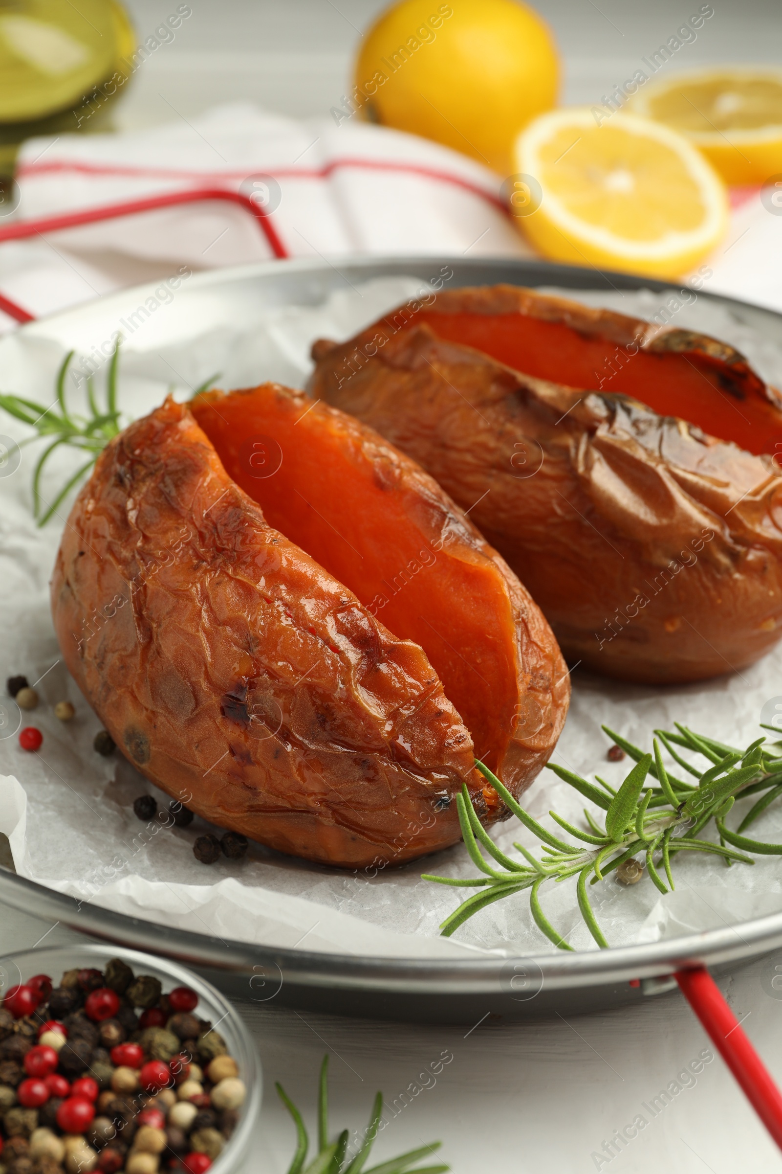 Photo of Tasty cooked sweet potatoes served with rosemary on table, closeup