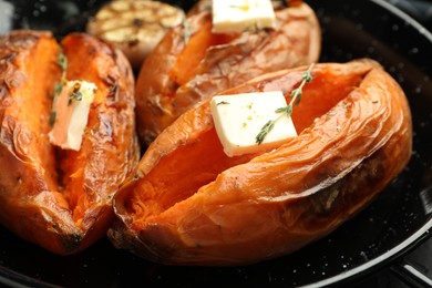 Photo of Tasty cooked sweet potatoes with feta cheese and thyme in frying pan, closeup