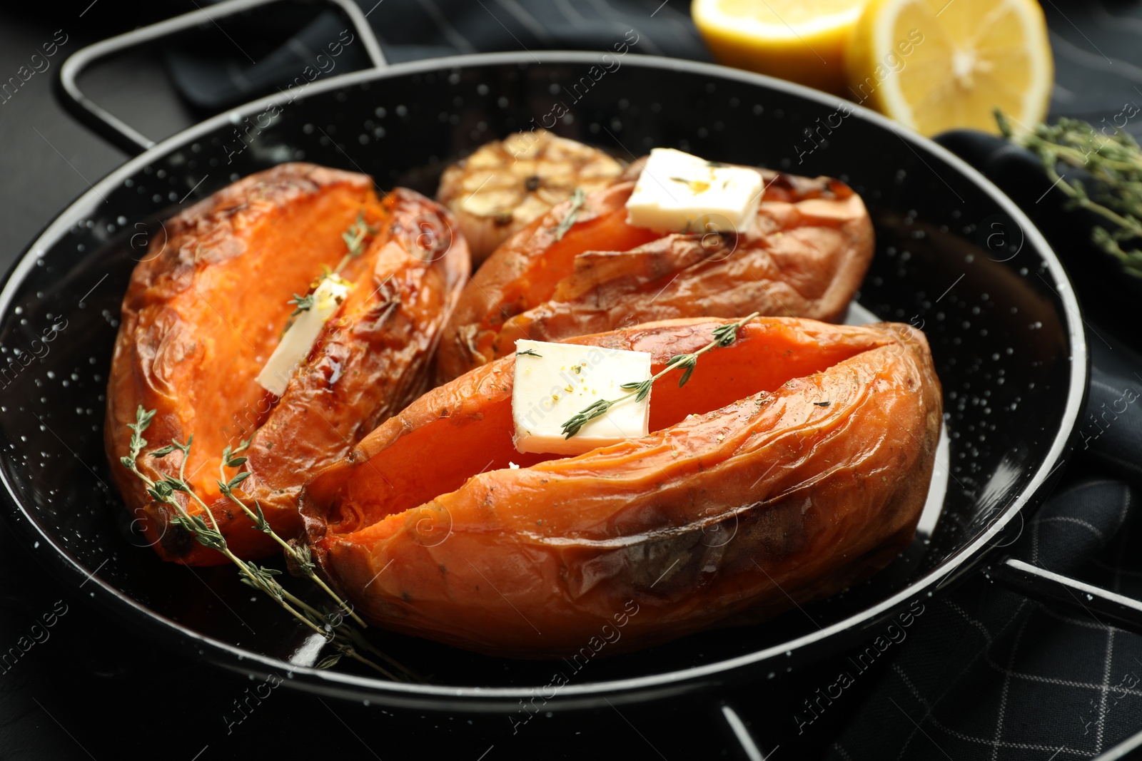 Photo of Tasty cooked sweet potatoes with feta cheese and thyme on table, closeup