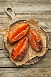 Photo of Tasty cooked sweet potatoes on wooden table, top view