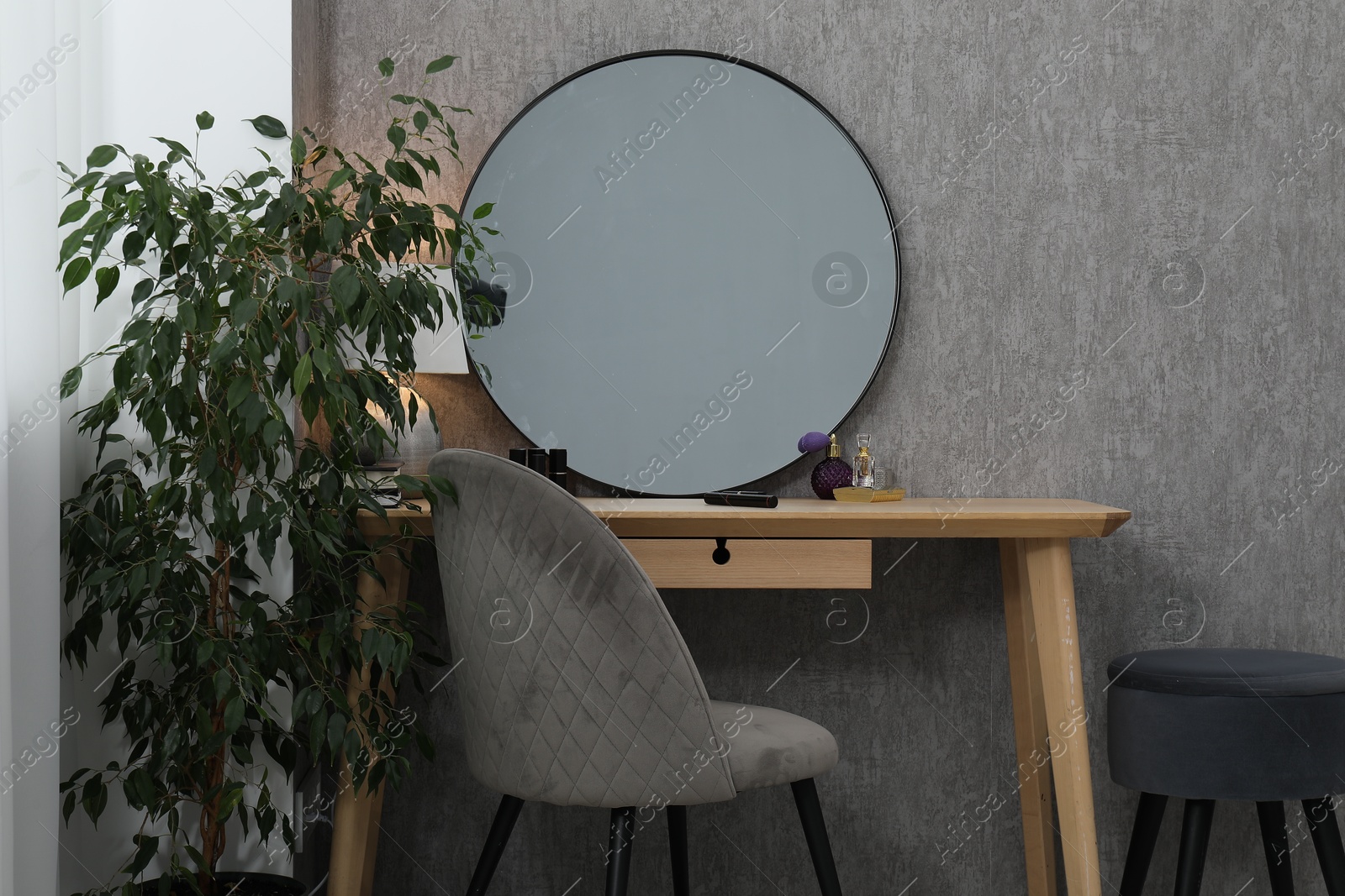 Photo of Mirror, dressing table, lamp, chair and houseplant indoors. Interior design