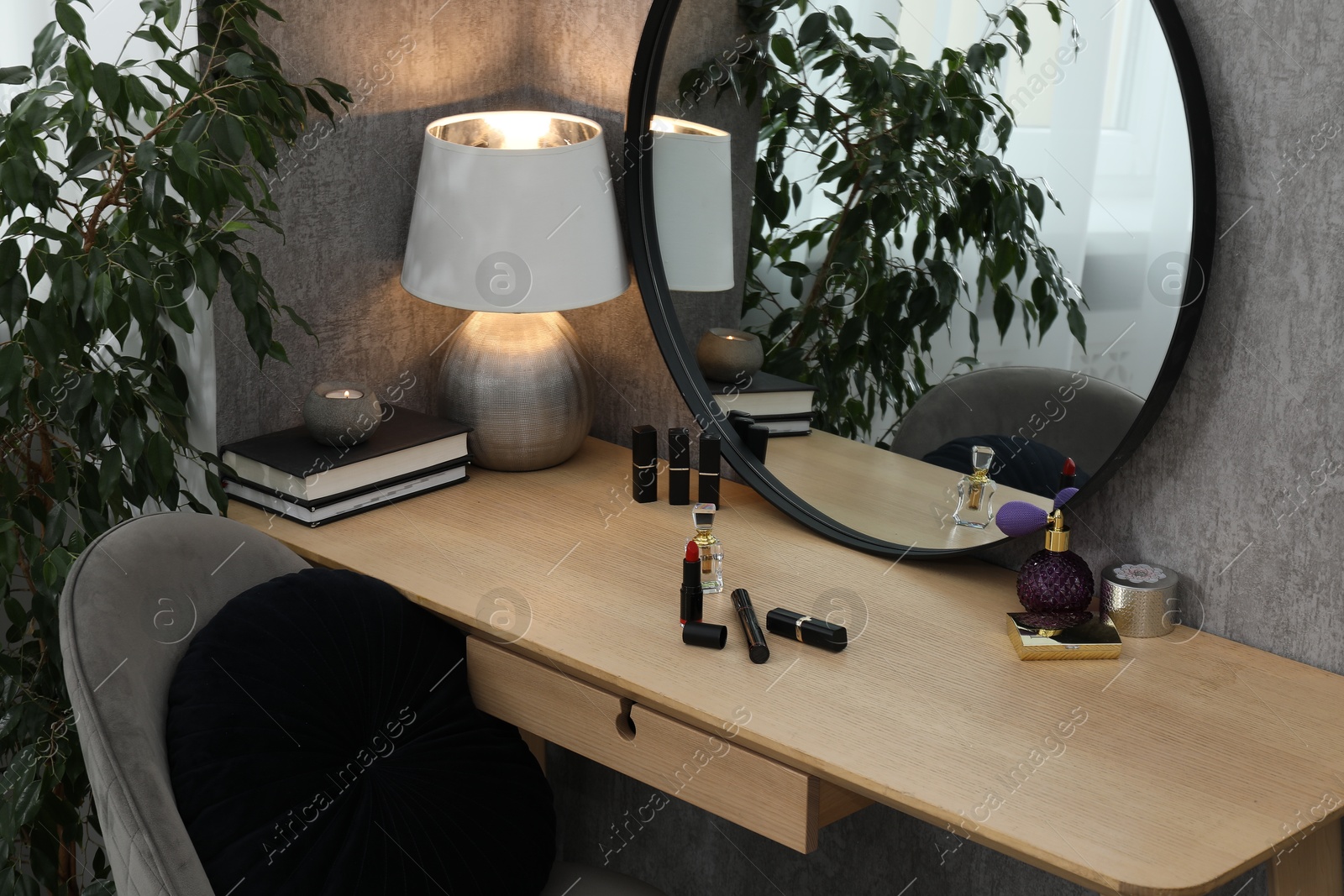 Photo of Mirror, dressing table, lamp, chair and houseplant indoors. Interior design