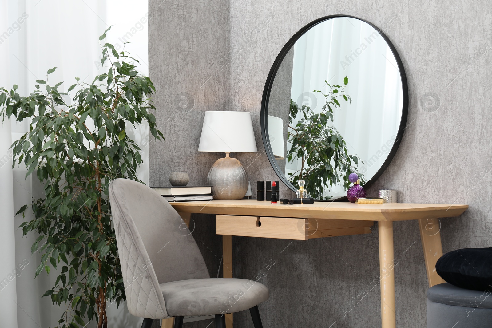 Photo of Mirror, dressing table, lamp, chair and houseplant indoors. Interior design