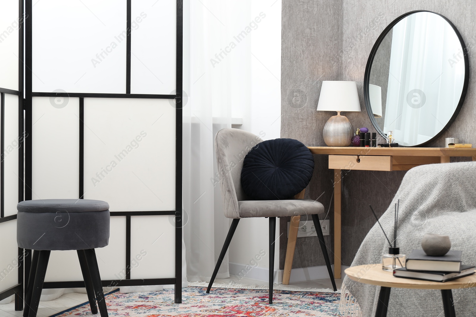 Photo of Mirror, dressing table, chairs and folding screen indoors. Interior design