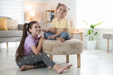 Cute little sisters spending time together at home