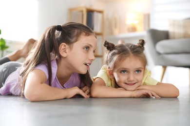 Cute little sisters spending time together at home