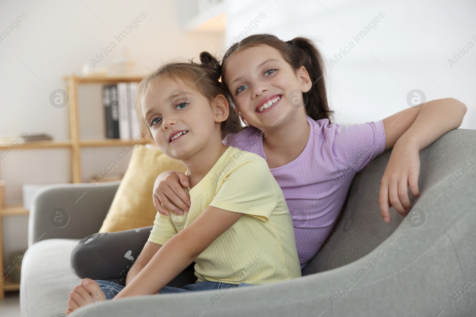 Photo of Cute little sisters spending time together at home