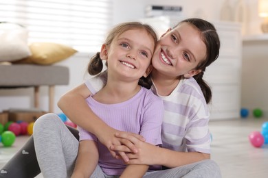 Photo of Portrait of cute little sisters at home