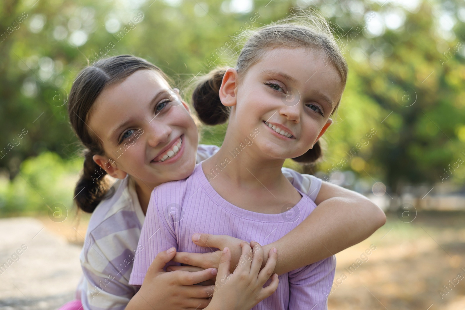 Photo of Portrait of cute little sisters in park