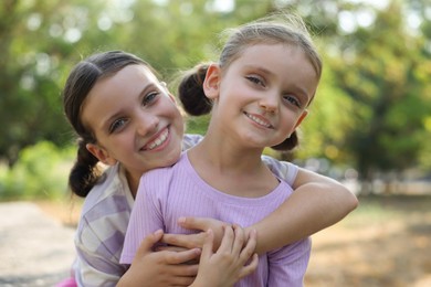 Portrait of cute little sisters in park