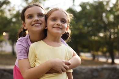 Photo of Portrait of cute little sisters in park