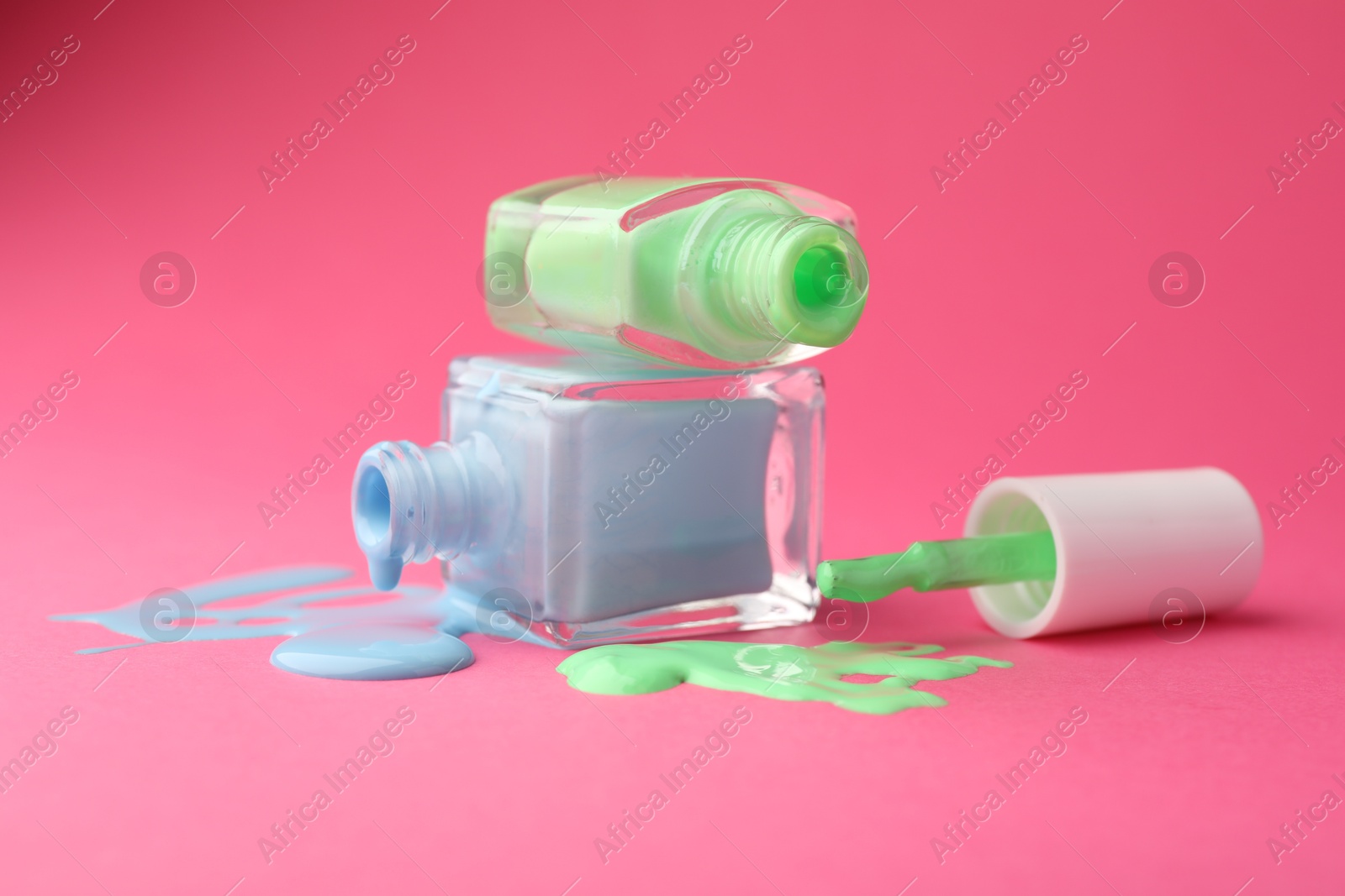 Photo of Bottles of nail polish on hot pink background