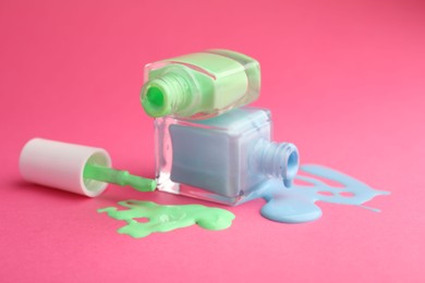 Photo of Bottles of nail polish on hot pink background