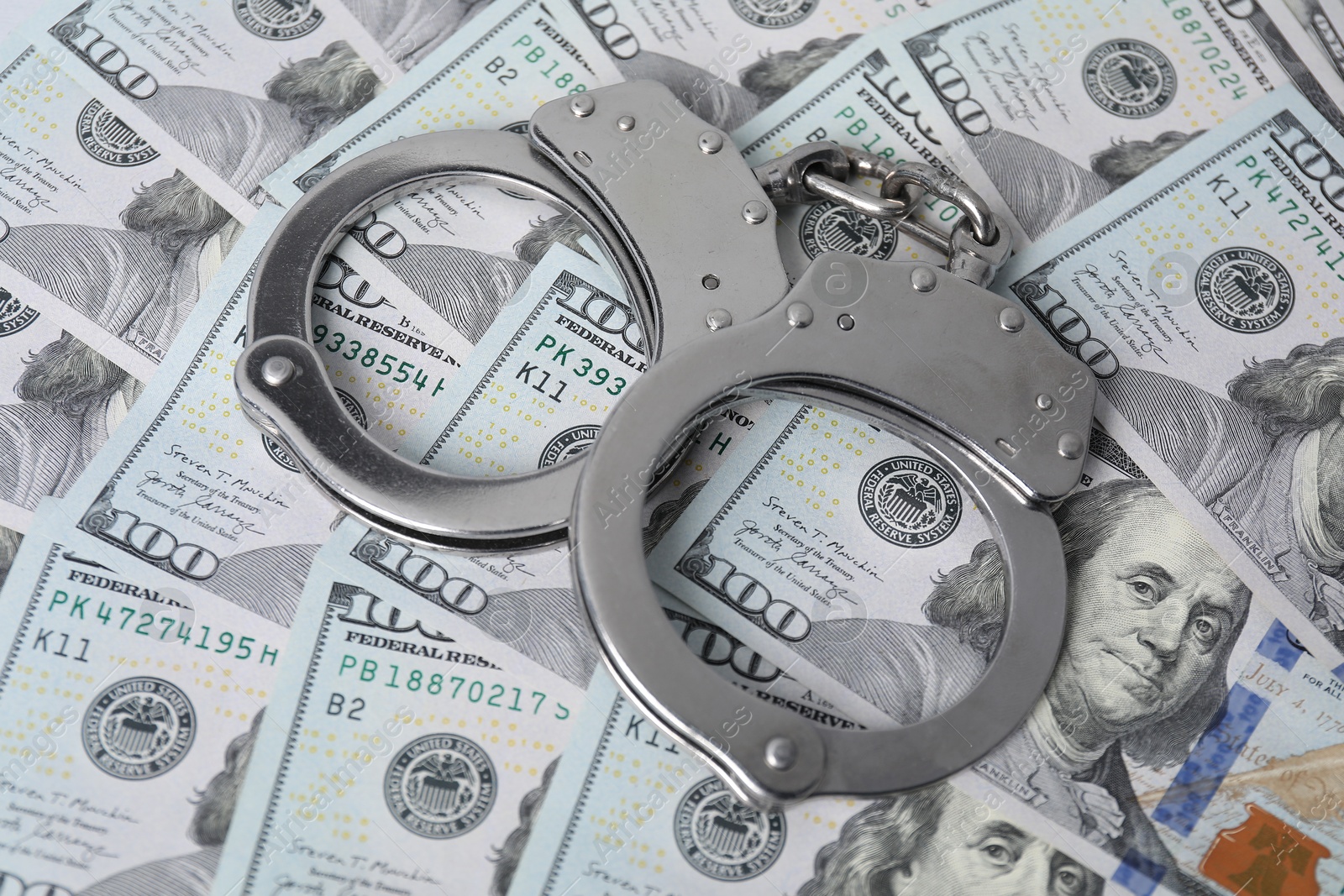 Photo of Corruption concept. Handcuffs on dollar banknotes, closeup