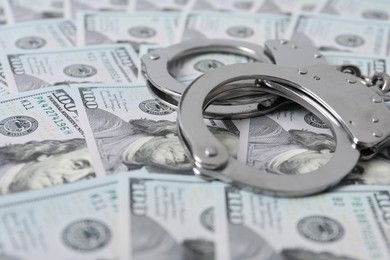 Corruption concept. Handcuffs on dollar banknotes, closeup