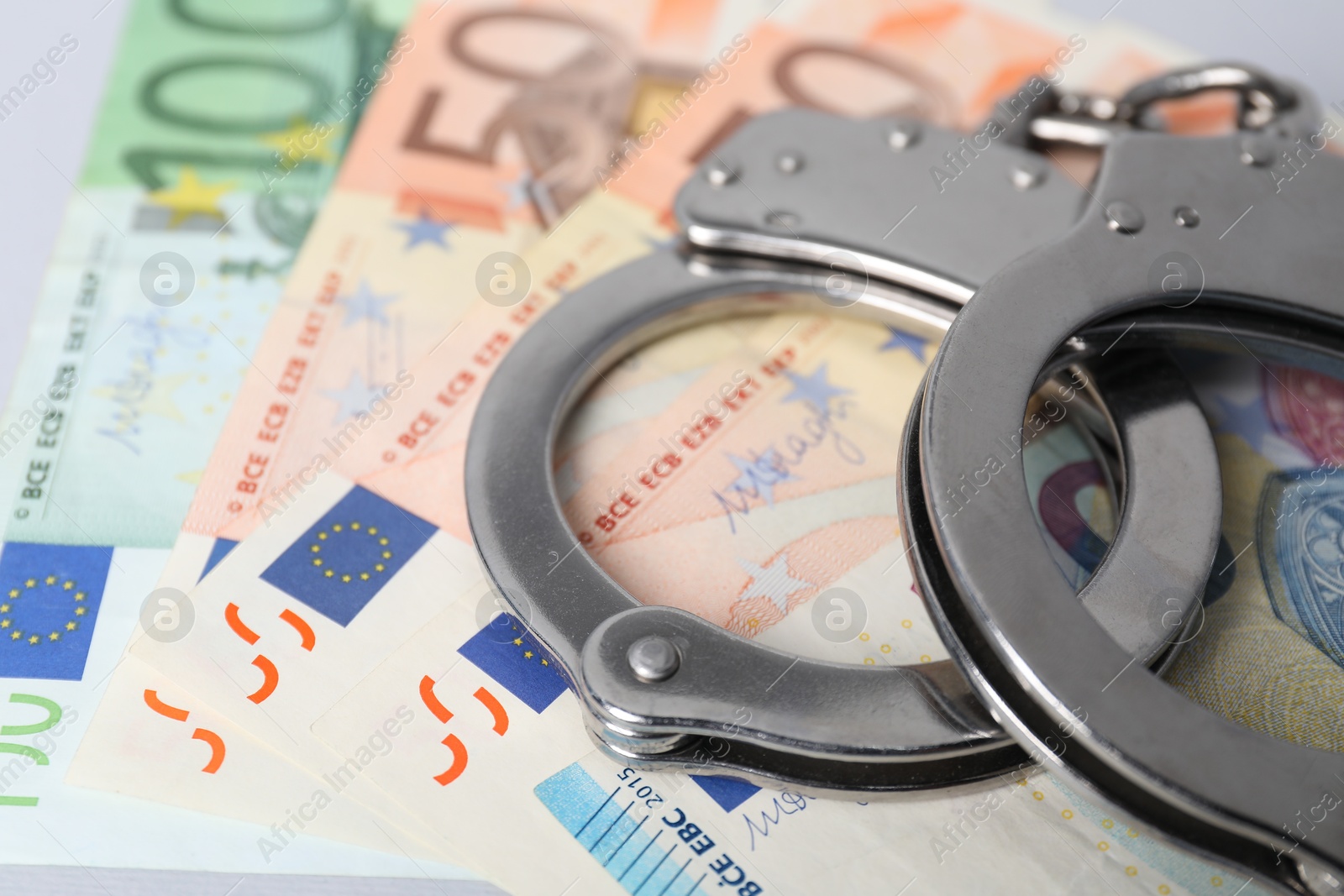 Photo of Corruption concept. Handcuffs on euro banknotes, closeup