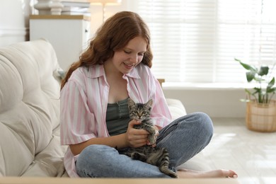 Photo of Beautiful teenage girl with cute cat at home