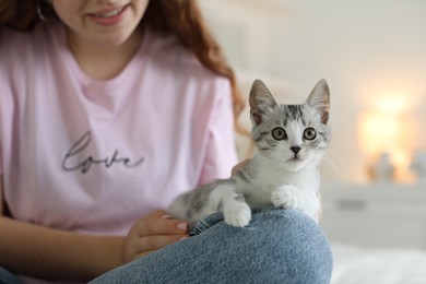 Teenage girl with cute cat indoors, closeup