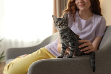 Photo of Teenage girl with cute cat on sofa at home, closeup