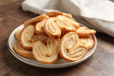 Photo of Tasty french palmier cookies on wooden table, closeup