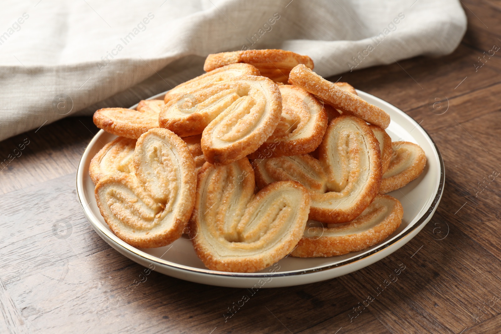 Photo of Tasty french palmier cookies on wooden table, closeup