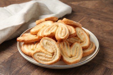 Photo of Tasty french palmier cookies on wooden table, closeup