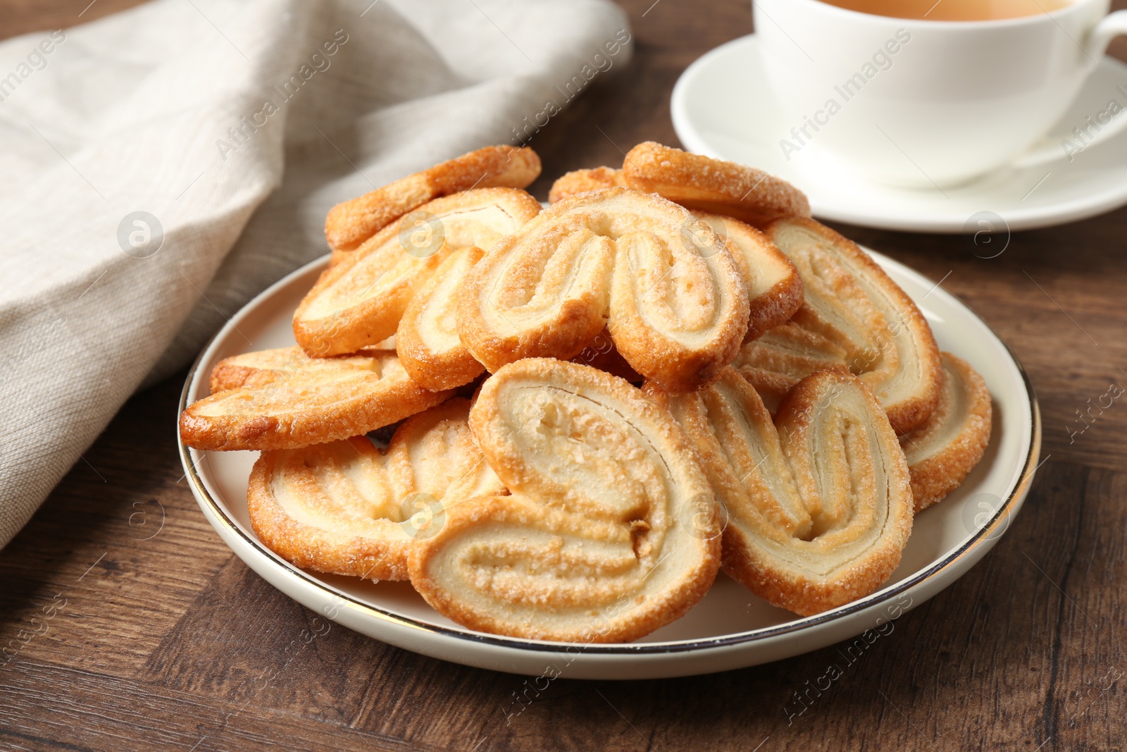 Photo of Tasty french palmier cookies on wooden table, closeup