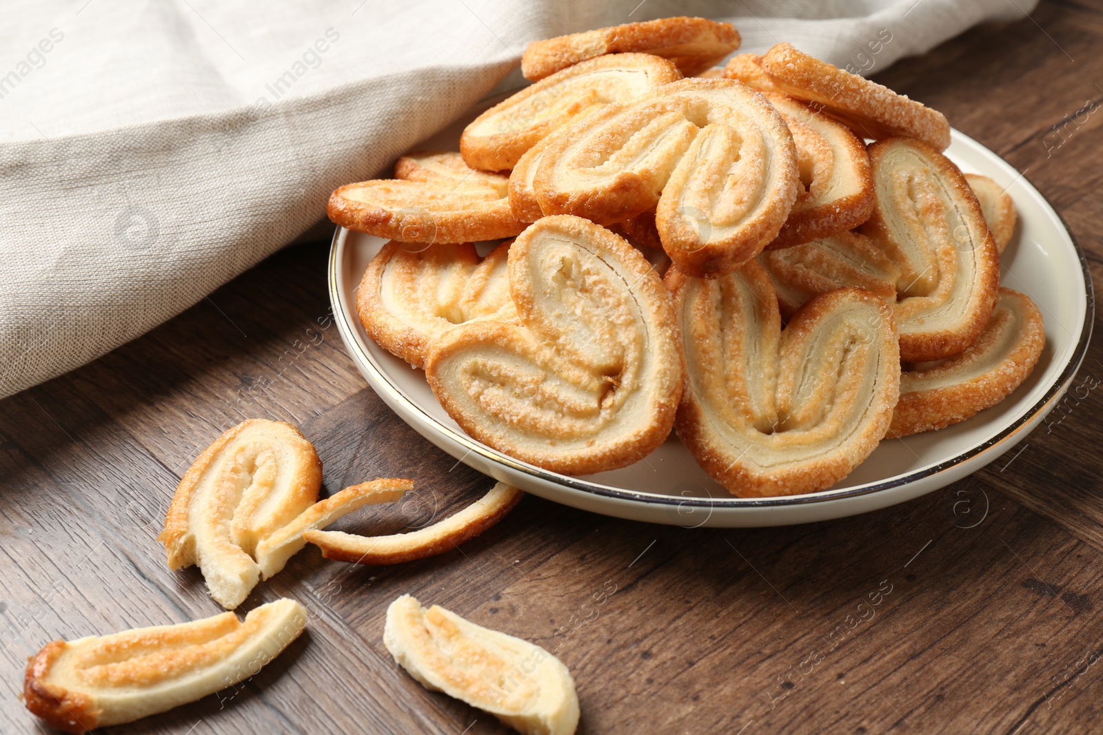 Photo of Tasty french palmier cookies on wooden table, closeup