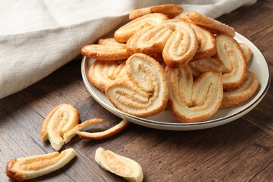 Photo of Tasty french palmier cookies on wooden table, closeup