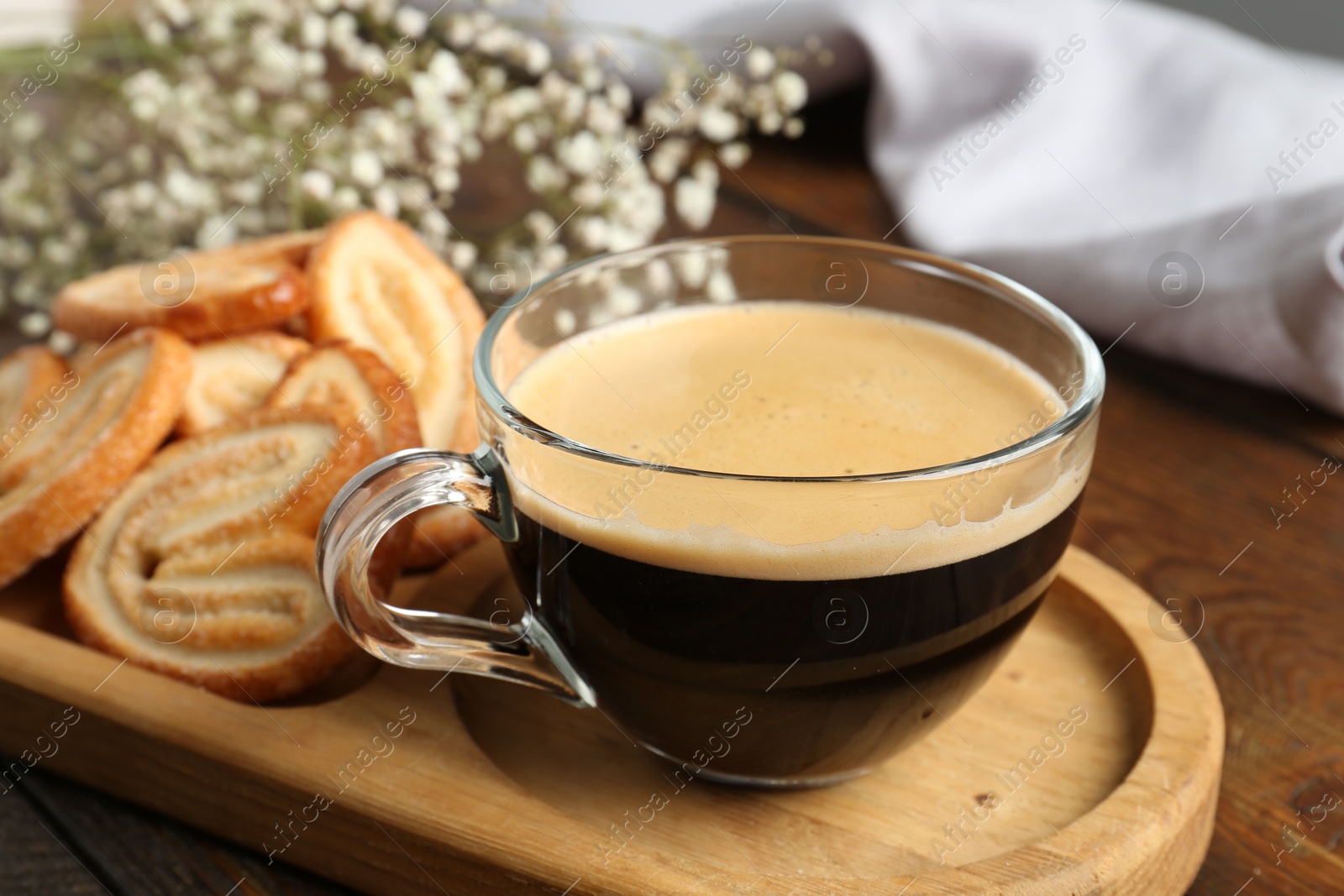 Photo of Tasty french palmier cookies and coffee on wooden table, closeup