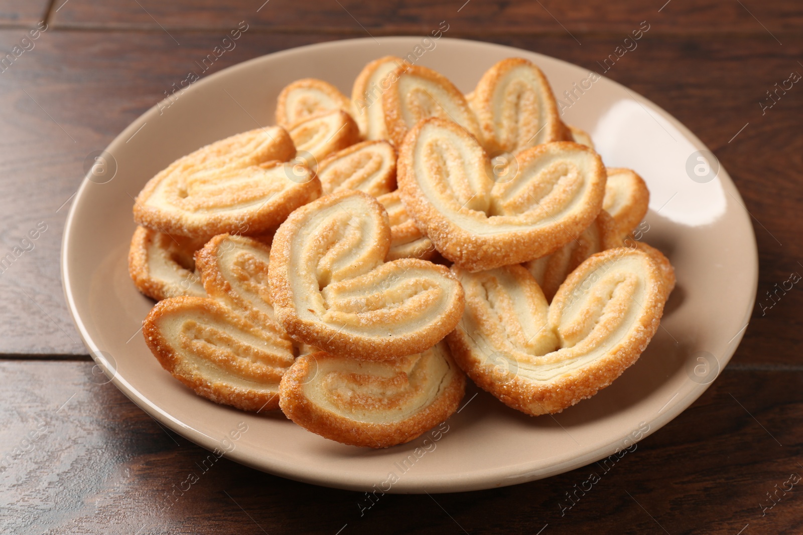 Photo of Delicious sweet palmier cookies on wooden table, closeup