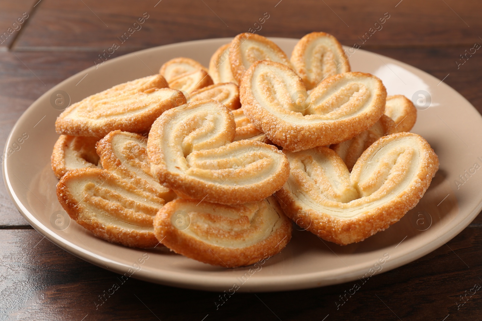 Photo of Delicious sweet palmier cookies on wooden table, closeup