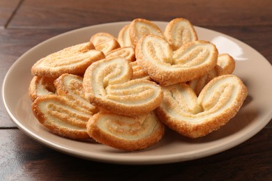 Photo of Delicious sweet palmier cookies on wooden table, closeup